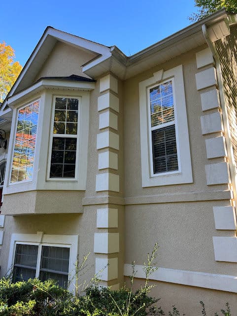 Exterior view of a modern house with decorative architecture and large windows.